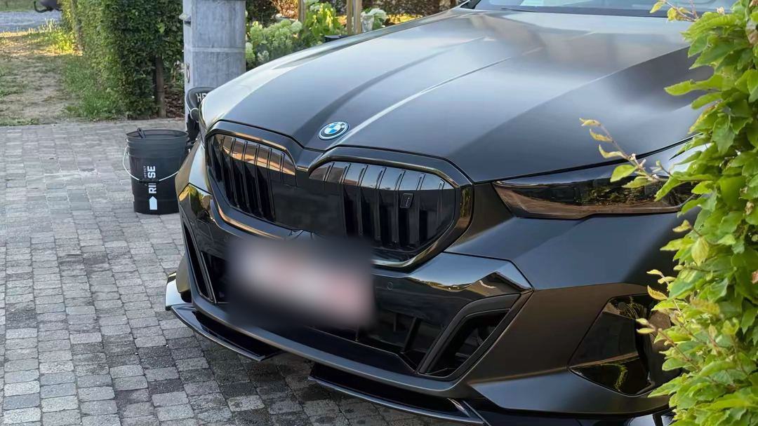 BMW i5 voorkant, satijnzwarte lak na een wasbeurt
